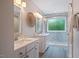 Bright bathroom with double vanities, quartz countertop, marble-look tile shower with glass door and tiled floors at 5205 Coffeetree Dr, Raleigh, NC 27613