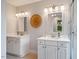 A well-lit bathroom with double vanities and white shaker cabinets featuring modern lighting and decor at 5205 Coffeetree Dr, Raleigh, NC 27613