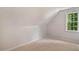 Attic bedroom boasts sloped ceilings and a window providing natural light at 5205 Coffeetree Dr, Raleigh, NC 27613