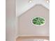Upper room featuring an oval window and a sloped ceiling, offering a unique architectural detail at 5205 Coffeetree Dr, Raleigh, NC 27613