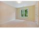 Spacious empty bedroom featuring carpet flooring and a large window letting in natural light at 5205 Coffeetree Dr, Raleigh, NC 27613