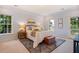 Beautifully staged bedroom with an area rug, white bedding, and large windows providing plenty of natural light at 5205 Coffeetree Dr, Raleigh, NC 27613