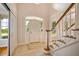 Bright and airy foyer featuring tile flooring, paneled walls, and a staircase with wood handrail at 5205 Coffeetree Dr, Raleigh, NC 27613