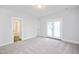 Carpeted bedroom with ensuite bathroom, closet, and a door leading to a balcony at 524 Folk Song Way, Wendell, NC 27591