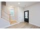 Bright entryway featuring light wood floors, stairs, and modern black door at 524 Folk Song Way, Wendell, NC 27591