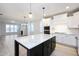 Modern kitchen with stainless appliances, white cabinets, granite countertops, and black island at 524 Folk Song Way, Wendell, NC 27591