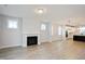 Open-concept living space with fireplace and view into the modern kitchen at 524 Folk Song Way, Wendell, NC 27591
