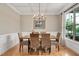 Dining room with hardwood floors, a chandelier, and woven chairs around a wooden table by a sunlit window at 5637 Garnet Meadow Rd, Knightdale, NC 27545