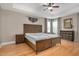Main bedroom with a tray ceiling, hardwood floors, and a large wooden bed, creating a relaxing retreat at 5637 Garnet Meadow Rd, Knightdale, NC 27545