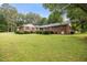 Brick home exterior features a well-manicured lawn, mature shrubs, and classic architectural details for inviting curb appeal at 658 Hiawatha Pl, Burlington, NC 27217