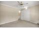 Carpeted bedroom with a ceiling fan and adjacent closet with doors at 658 Hiawatha Pl, Burlington, NC 27217