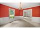 Traditional dining room featuring red walls, classic trim, and a vintage chandelier at 658 Hiawatha Pl, Burlington, NC 27217