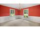 Bright dining room with vibrant red walls, classic wainscoting, and large windows for plenty of natural light at 658 Hiawatha Pl, Burlington, NC 27217