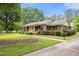 Brick home featuring black shutters, manicured bushes, and a sidewalk leading to the inviting yellow front door at 658 Hiawatha Pl, Burlington, NC 27217