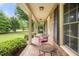 Charming brick porch with comfortable seating, decorative plants, and an inviting view of the landscaped yard at 658 Hiawatha Pl, Burlington, NC 27217