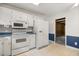 Functional kitchen featuring white appliances, tile floors and a doorway at 658 Hiawatha Pl, Burlington, NC 27217