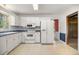 Functional kitchen with white appliances, tile floors and a connecting room at 658 Hiawatha Pl, Burlington, NC 27217