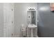 Powder room with pedestal sink, mirror, and white trim at 800 Savannah Ridge Rd # 109, Holly Springs, NC 27540