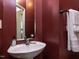 Stylish powder room featuring a pedestal sink, modern fixtures, and warm paint color at 8001 Strawberry Meadows St, Raleigh, NC 27613