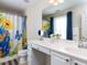 Well-lit bathroom featuring white vanity, floral shower curtain, with butterfly accents, and a large mirror at 8001 Strawberry Meadows St, Raleigh, NC 27613