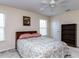 Comfortable bedroom featuring patterned bedspread, a ceiling fan, and natural light from the windows at 8001 Strawberry Meadows St, Raleigh, NC 27613