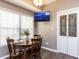 Cozy dining area featuring a round table, wood chairs, and a TV, bathed in natural light from the window at 8001 Strawberry Meadows St, Raleigh, NC 27613
