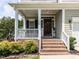 Inviting front porch with brick steps, white railings, and a dark wood front door at 8001 Strawberry Meadows St, Raleigh, NC 27613