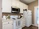 Well-lit kitchen featuring white appliances and cabinets with wooden floor at 8001 Strawberry Meadows St, Raleigh, NC 27613