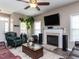 Comfortable living room with a fireplace, large TV, and neutral color palette at 8001 Strawberry Meadows St, Raleigh, NC 27613