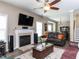 Cozy living room featuring a fireplace, hardwood floors, and modern ceiling fan at 8001 Strawberry Meadows St, Raleigh, NC 27613
