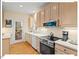 Well-maintained kitchen featuring stainless appliances and hardwood floors, overlooking covered porch at 805 N Columbia St, Chapel Hill, NC 27516