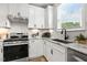 Bright kitchen with white cabinetry, granite countertops, stainless steel appliances, and tile backsplash at 8217 White Star Dr, Fuquay Varina, NC 27526