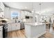 The bright, open kitchen features an island with white cabinets, stainless appliances, and granite countertops at 8217 White Star Dr, Fuquay Varina, NC 27526
