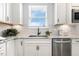 Modern kitchen featuring white cabinets, granite countertops, stainless steel appliances, and a window above the sink at 8217 White Star Dr, Fuquay Varina, NC 27526