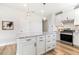 Bright kitchen features an island with granite countertops, white cabinets, and stainless steel appliances at 8217 White Star Dr, Fuquay Varina, NC 27526