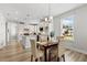 Open-concept kitchen and dining area with modern lighting, white cabinets, and stainless steel appliances at 8217 White Star Dr, Fuquay Varina, NC 27526