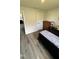 Bedroom featuring wood-look flooring, a dark bed, and a wood dresser at 8680 Kenridge Ln, Fuquay Varina, NC 27526