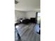 Spacious bedroom with wood-look flooring, two windows, and simple, modern furnishings at 8680 Kenridge Ln, Fuquay Varina, NC 27526