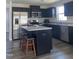 Modern kitchen with black cabinetry, stainless steel appliances, and an island with barstool seating at 8680 Kenridge Ln, Fuquay Varina, NC 27526