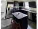 Well-equipped kitchen with black cabinets, stainless steel appliances, granite countertops, and a kitchen island at 8680 Kenridge Ln, Fuquay Varina, NC 27526