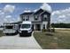 Two-story home with gray siding, dark blue gables, manicured lawn and long driveway at 88 W Emily Gardens Dr, Selma, NC 27576