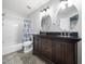 Bright bathroom showcasing dual vanity, modern lighting fixtures and shower-tub combination at 8828 Deerland Grove Dr, Raleigh, NC 27615