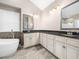 Luxurious bathroom featuring dual sinks, a soaking tub, and elegant fixtures at 8828 Deerland Grove Dr, Raleigh, NC 27615