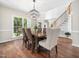 Elegant dining room featuring a chandelier, hardwood floors, and an open layout at 8828 Deerland Grove Dr, Raleigh, NC 27615