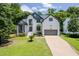 Charming two-story home with landscaped yard, a two-car garage, and beautiful architectural details at 8828 Deerland Grove Dr, Raleigh, NC 27615