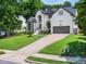 Charming two-story home with landscaped yard, a two-car garage, and beautiful architectural details at 8828 Deerland Grove Dr, Raleigh, NC 27615