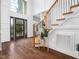 Spacious foyer featuring a grand staircase, hardwood floors, and abundant natural light at 8828 Deerland Grove Dr, Raleigh, NC 27615
