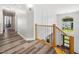 Upstairs hallway with views of a manicured backyard visible from a large window at the stair landing at 8828 Deerland Grove Dr, Raleigh, NC 27615