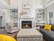Bright living room features a cozy fireplace flanked by built-in shelving and comfortable seating at 8828 Deerland Grove Dr, Raleigh, NC 27615
