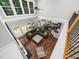 Aerial view of a spacious living room with a large sectional, hardwood floors, and abundant natural light at 8828 Deerland Grove Dr, Raleigh, NC 27615